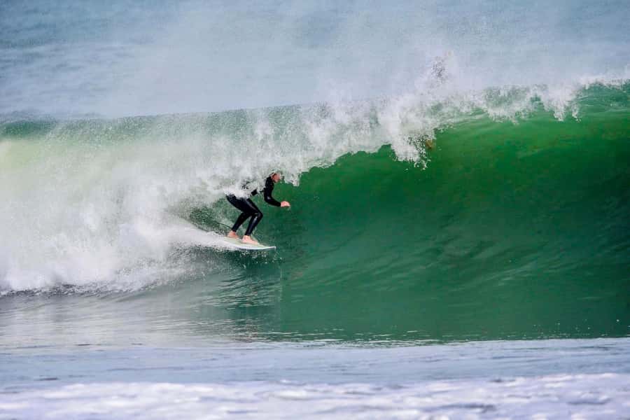 Auckland: Group Surfing Lesson with Muriwai Surf School - In the water: catching waves with steady help